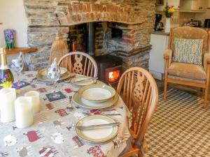 a dining room table with a fireplace in a living room at The Bolthole - 28188 in Yelverton