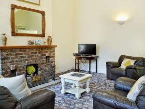 a living room with two couches and a fireplace at Stable Cottage 1 in Rudston