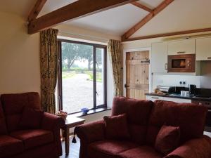 a living room with a couch and a large window at Brunos Bothy in Wigton