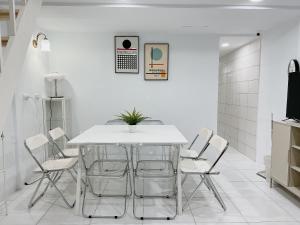 a white dining room with a white table and chairs at Soda White Tainan Homestay in Tainan