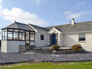 een wit huis met een blauwe deur bij Bwthyn Pereos in Llanrhwydrys