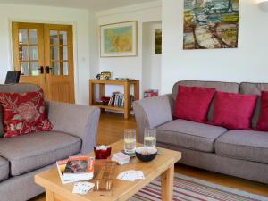 Tre Anna Lodge في Dwyran: غرفة معيشة مع كنبتين وطاولة قهوة