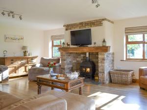 a living room with a fireplace and a tv at Barley Edge in Hornsea