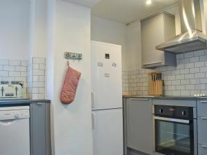 a kitchen with a stove and a refrigerator at Clipper Cottage in Wells next the Sea