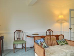 uma sala de estar com um sofá, uma mesa e cadeiras em Acorn Cottage em Todenham
