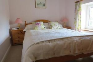 een slaapkamer met een groot bed en een raam bij Garries Cottage in Bassenthwaite