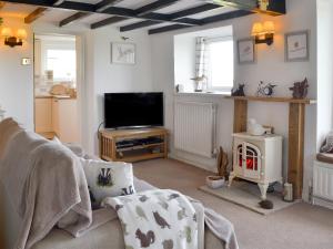 a living room with a flat screen tv and a couch at Salem Fach - Hw7587 in Llanrhwydrys