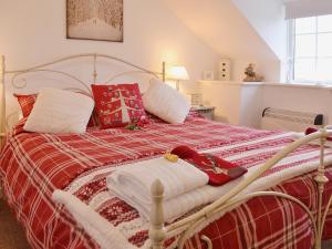 a bed with red and white blankets and pillows at Salem Fach - Hw7587 in Llanrhwydrys