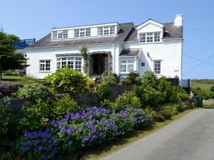 a white house with flowers in front of it at Salem Fach - Hw7587 in Llanrhwydrys