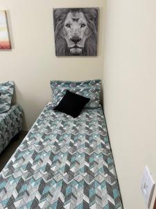 a bedroom with a bed with a lion picture on the wall at Casa em Brotas Turismo de aventura in Brotas