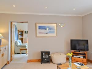 a living room with a flat screen tv on a wall at Taigh an Tuath in Isleornsay