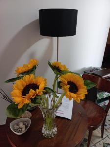 un vase rempli de fleurs jaunes sur une table dans l'établissement Hotel Cocó Cochoa, à Viña del Mar
