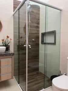 a bathroom with a shower with glass doors at Casa em Brotas Turismo de aventura in Brotas