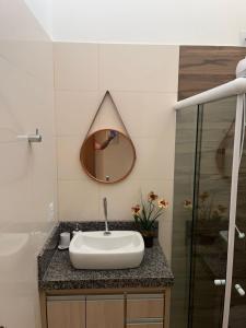 ein Bad mit einem Waschbecken und einem Spiegel in der Unterkunft Casa em Brotas Turismo de aventura in Brotas