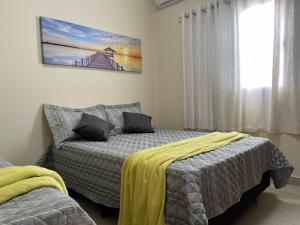 a bedroom with two beds and a window at Casa em Brotas Turismo de aventura in Brotas