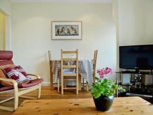 een woonkamer met een tafel en stoelen en een televisie bij Palm Leas - E3587 in Ilfracombe