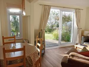 een woonkamer met een tafel en een glazen deur bij Palm Leas - E3587 in Ilfracombe