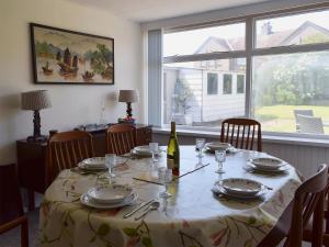 a dining room with a table with a bottle of wine at Kannier Cottage in Saint Monance