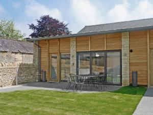 a patio with a table and chairs next to a building at The Hayloft - Nab in Aynho