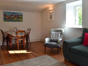 sala de estar con mesa y sillas en Pear Tree House Annexe, en Holmfirth