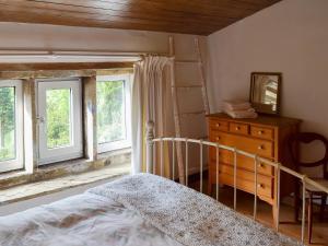 1 dormitorio con 1 cama, vestidor y ventanas en Pear Tree House Annexe, en Holmfirth