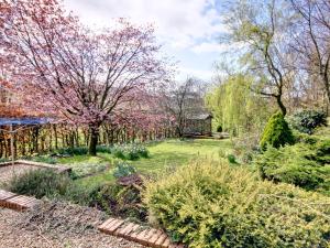 ogród z kwitnącymi drzewami i dom w tle w obiekcie The Cottage w mieście Girvan