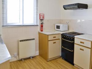 a kitchen with a stove and a microwave at Ferrybridge View in Wyke Regis