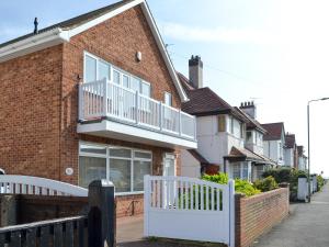 a brick house with a white fence in front of it at The Beach Hut in Bridlington