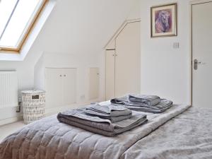 a bedroom with a bed with towels on it at The Lodge At The Granary in Alderton