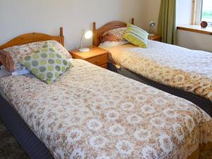 a bedroom with two beds and a window at Horsemans in John O Groats