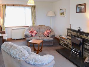 a living room with a couch and a fireplace at Horsemans in John O Groats