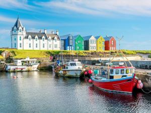 a group of boats in the water in front of a building at Horsemans in John O Groats