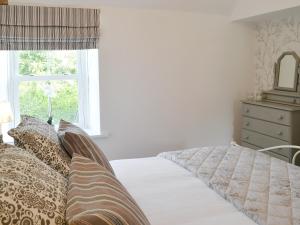 a bedroom with a bed with a window and a dresser at Melandra in Smeafield