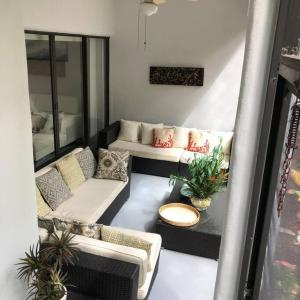 a living room with couches and plants on a balcony at Naples Dream at WTC with Heated Pool SPA Sauna 7 bicycles and 3 mls to beach in Naples