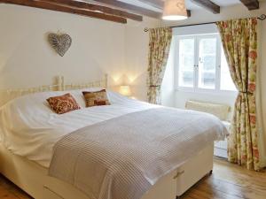 a bedroom with a white bed and a window at The Old Sweet Shop in Hook Norton