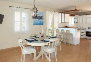 a dining room and kitchen with a table and chairs at Captain's Quarters at Fiscardo Waterfront-feel the breeze in Fiskardho