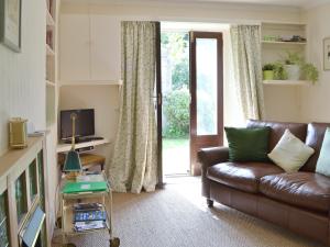 a living room with a leather couch and a sliding glass door at Belle Vue-ukc778 in Eggleston