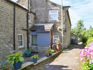 an old stone house with a blue door and potted plants at Belle Vue-ukc778 in Eggleston