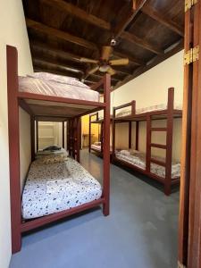 a room with three bunk beds in it at Hostel Tuanis Surf Camp in Santa Teresa Beach