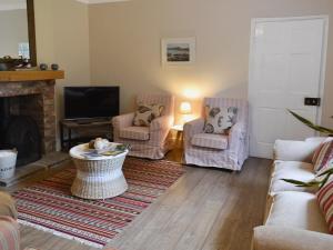 a living room with two chairs and a fireplace at The Garden Cottage in Rudston