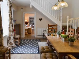 a living room with a table and a staircase at The Garden Cottage in Rudston