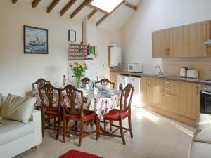a kitchen and dining room with a table and chairs at Dove Cottage - 25117 in Flamborough