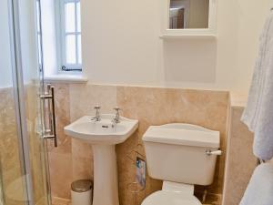 a bathroom with a toilet and a sink at Princess Cottage in Martin