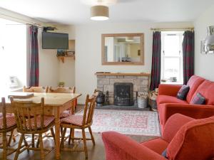 a living room with a table and a fireplace at Rowan Cottage in Glenrossal