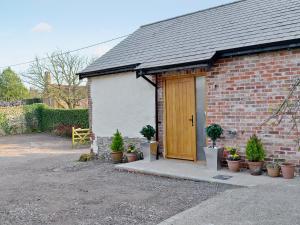 a brick house with a wooden door and potted plants at Princess Cottage in Martin