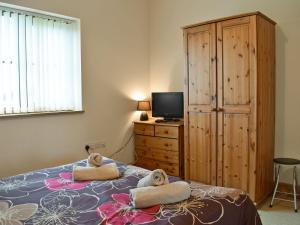 a bedroom with a bed with towels on it at Ty Nant in Llanon