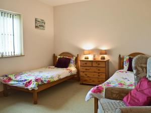 a bedroom with two twin beds and a dresser at Ty Nant in Llanon