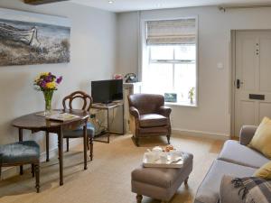 a living room with a couch and a table at Time Cottage in Coltishall