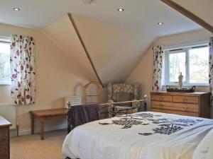 a bedroom with a bed and a dresser and a window at The Hurstings in Bridgnorth