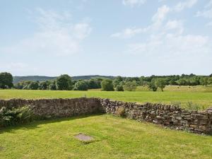 un muro di pietra nel mezzo di un campo di The Cowshed a Froghall
